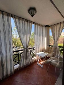 a living room with curtains and a couch and a table at Oasis Resort Apartments in Lozenets