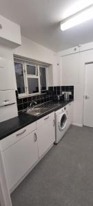 cocina blanca con lavadora y fregadero en Crystal Barking Service Accommodation, en Barking 5 fotos más