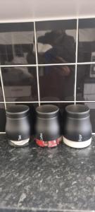 tres ollas sentadas en un estante en una cocina en Crystal Barking Service Accommodation, en Barking