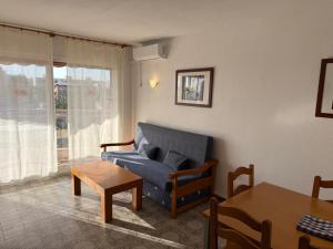 a living room with a blue couch and a table at El Pinar Fuente Luminosa in Salou