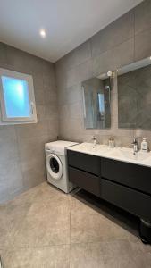 ein Badezimmer mit Waschmaschine und Waschbecken in der Unterkunft Le spacieux au dernier étage avec vue dégagée in Arthaz-Pont-Notre-Dame