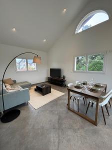 ein Wohnzimmer mit einem blauen Sofa und einem Tisch in der Unterkunft Le spacieux au dernier étage avec vue dégagée in Arthaz-Pont-Notre-Dame