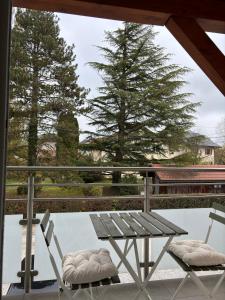 einen Picknicktisch und zwei Stühle auf dem Balkon in der Unterkunft Le spacieux au dernier étage avec vue dégagée in Arthaz-Pont-Notre-Dame
