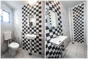 a bathroom with a black and white checkered wall at Hotel Amrapali Udaipur in Udaipur