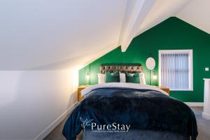 a bedroom with green walls and a bed at Beautiful Bradford 3 Bedroom Home Sleeps 8 with Parking by PureStay in Wibsey