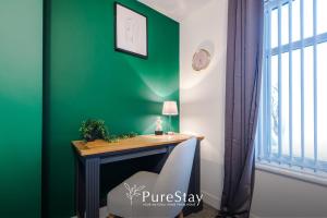a green room with a desk and a chair at Beautiful Bradford 3 Bedroom Home Sleeps 8 with Parking by PureStay in Wibsey +102 photos
