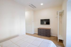 una camera da letto con un letto e una TV a parete di Blue Dream Suites a Salerno Altre 49 foto