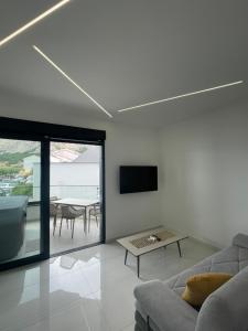 a living room with a couch and a table at Villa San Sebastian - apartments on the beach with jacuzzi in Baška