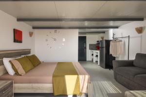 un salon avec un canapé et une horloge au mur dans l'établissement Villa Miranda Roshi, à Toroni