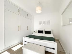 a white bedroom with a bed and a white cabinet at Apartment Praia Rocha Candimar Salvia in Portimão