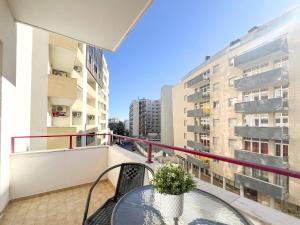 a balcony with a table and chairs and a building at Apartment Praia Rocha Candimar Salvia in Portimão