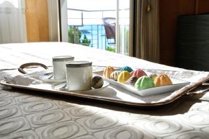 a tray with a plate of pastries on a bed at Sole Mare in Ventimiglia