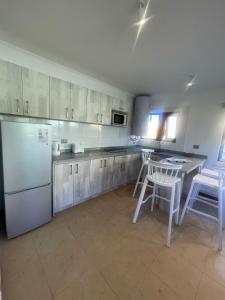 a kitchen with a refrigerator and a table and chairs at "Marenostro" Dpto #2, edificio frente al mar in Algarrobo