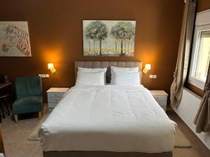 a bedroom with a large bed and a blue chair at Akrotiri studios in Samothraki