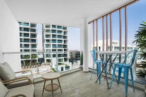 a balcony with blue chairs and a table and some windows at Rivi Luxury 42 Suites - By SEAELO EILAT in Eilat
