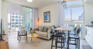 a living room with a couch and a table at Rivi Luxury 42 Suites - By SEAELO EILAT in Eilat