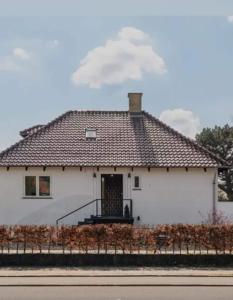 a white house with a brown roof at 1-bedroom villa apartment in CPH in Gentofte