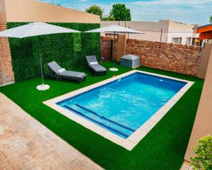 a swimming pool with two chairs and umbrellas at Lavani Lodge in Lerulaneng