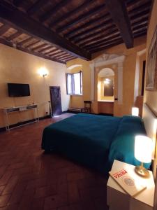 a bedroom with a green bed and a television at My home apartments in Pienza