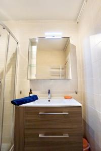 une salle de bain avec un lavabo et un miroir dans l'établissement L'essentiel - parking - centre ville, à Concarneau 13 autres photos