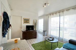 un salon avec un canapé et une télévision dans l'établissement L'essentiel - parking - centre ville, à Concarneau