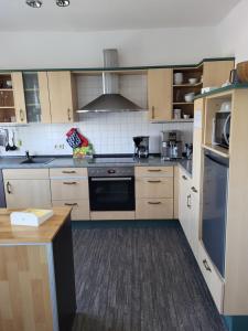 a kitchen with wooden cabinets and a stove top oven at Alleeblick in Ballenstedt