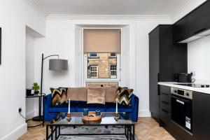 a living room with a blue couch in a kitchen at 2 Bedroom Apartment-Free Parking in Hawick