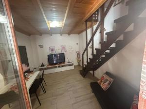 a living room with a staircase and a television at MuSa Apartment in Catania