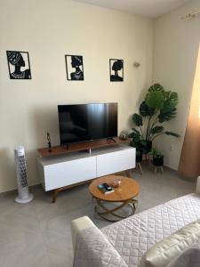 a living room with a flat screen tv on a cabinet at T1 Mindelo City Center in Mindelo
