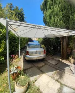a car parked under a white canopy in a driveway at Appartement dans villa provençale, jardins et 3VTT disponibles in Digne-les-Bains