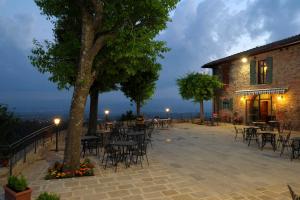 a patio with tables and chairs next to a building at La Pietra Piana Casa Vacanze in Reggello