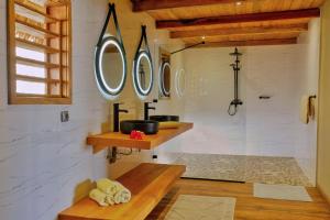 a bathroom with a sink and two mirrors on the wall at Manja Kely Lodge - Nosy Komba Island in Nosy Be +59 photos