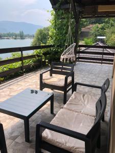 a patio with chairs and a swing and a table at The Sloth - vacation home in Simići