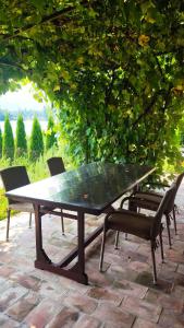 a ping pong table and chairs under a tree at The Sloth - vacation home in Simići +8 photos