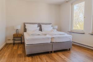 two twin beds in a room with a window at Penthouse in Hildesheims Philosophen Viertel in Hildesheim