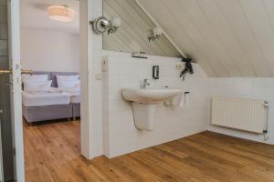 a bathroom with a sink and a bed at Penthouse in Hildesheims Philosophen Viertel in Hildesheim +22 photos