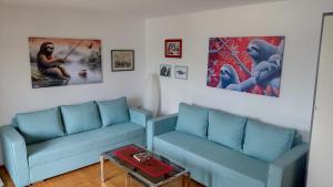 a living room with two blue couches and a table at The Sloth - vacation home in Simići
