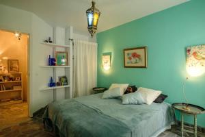 una camera da letto con un letto con una parete blu di Casa Petra a Canillas de Aceituno