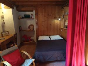a small bedroom with a bed and a chair at Gite Seguret in Gresse-en-Vercors