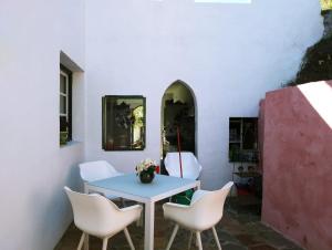 tavolo e sedie in una stanza con parete bianca di Casa Petra a Canillas de Aceituno