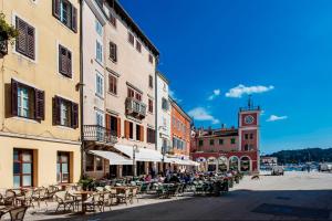 a street with tables and chairs and a clock tower at Apartment Lux Rovinj in Rovinj