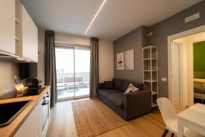 a small living room with a couch and a kitchen at Design a 2 passi dal mare in Alba Adriatica