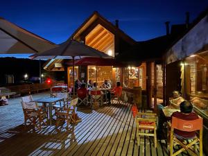 a group of people sitting on a deck at night at NATIVA MOUNTAIN SUITES in Malalcahuello