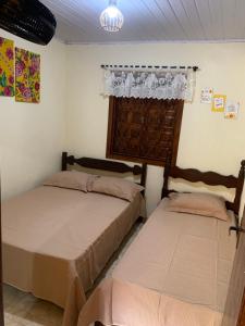 a bedroom with two beds and a chandelier at Estância dos Lagos in Cláudio +19 photos