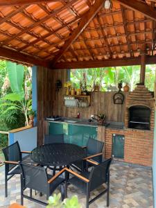 a patio with a table and chairs and an outdoor kitchen at Estância dos Lagos in Cláudio