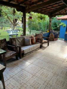 a porch with a couch and chairs on a patio at Estância dos Lagos in Cláudio