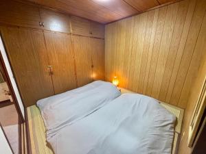 石垣島にあるOhaco Hostel Ishigakiの木製キャビネット付きの客室の小さなベッド1台分です。