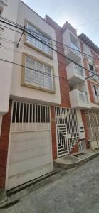 a house with a white garage door on a street at Apartahotel Rubí San Gil in San Gil