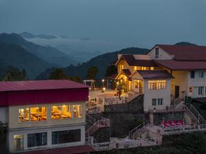 a group of buildings with mountains in the background at Tree of Life Highlands Mussoorie in Mussoorie