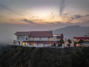 a house on top of a hill with a sunset at Tree of Life Highlands Mussoorie in Mussoorie +61 photos